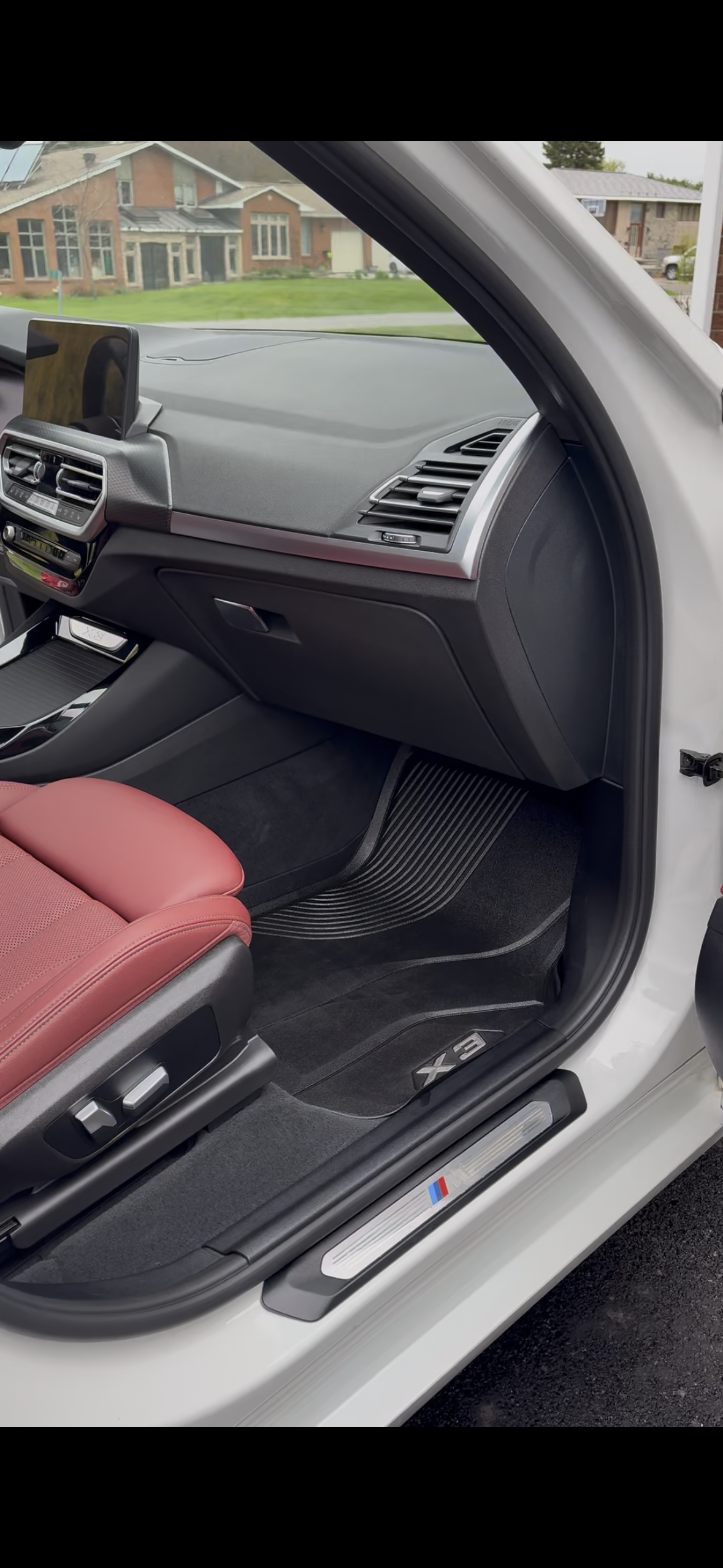 BMW door open — clean interior, residential setting